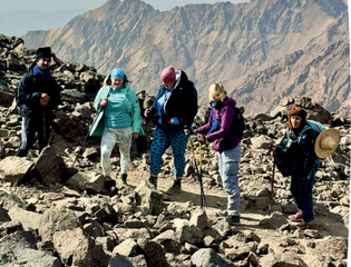 3 people smiling while up a rocky mountain