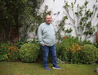 A man standing proudly in his garden