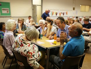 A group of people round a table laughing