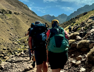 Two people trekking up a mountain